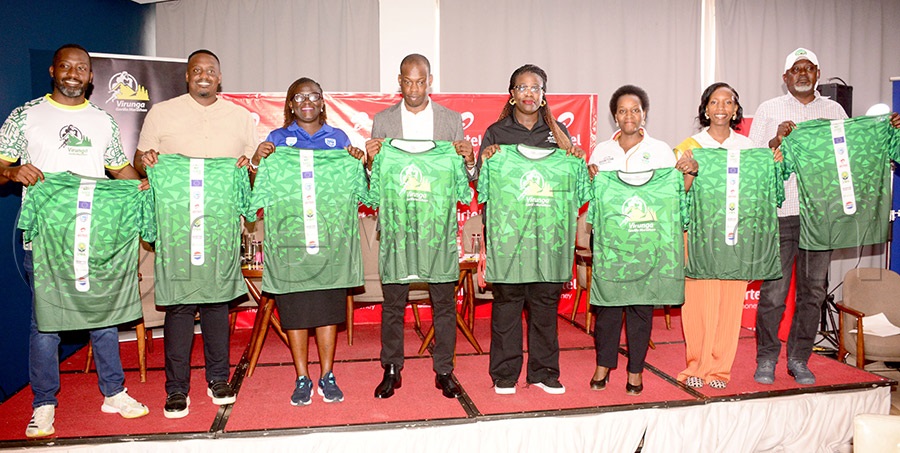 The State Minister for Tourism, Martin Mugarra (4th left) is joined by Kenneth Kamukama (left) one of the event organizers and sponsors' representatives Roy Ronald Tumwizire (2nd left), Diana Ondoga (3rd left), Hope Ekudu, Dorcus Rukundo Twesigomwe and UWA Ambassador Bridget Karungi  and Emmanuel Mugisha (right) as they unveil the Virunga Marathon kit at Golden Turip Hotel, April 24, 2026. Photo by Michael Nsubuga