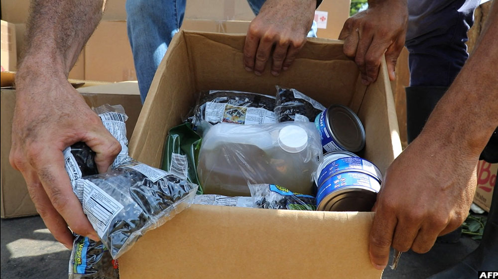 The aid package includes rice, beans, oil, and canned goods, along with hygiene products like soap, detergent, toothbrushes, and chlorine tablets for purifying water.
