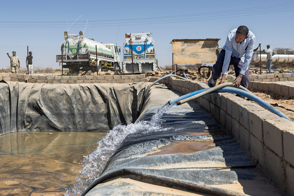  A worker adjusts pipes as water from a borehole is pumped into a water pan for collection by tanker trucks distributing it to surrounding drought-stricken farmlands in Lallays village, near Hargeisa, on February 17, 2026. (Photo by Tony KARUMBA / AFP)
