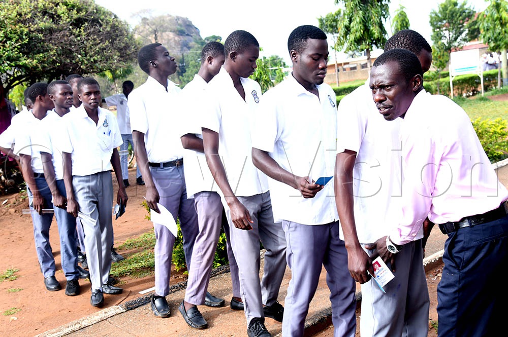 An invigilator checking the boys of Soroti SS before they were allowed into the examination room. (Credit: Godfrey Ojore)