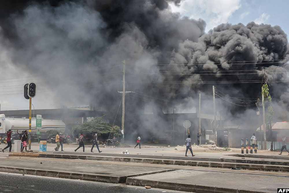 Protesters gather near burning buildings and barricades as clashes erupt in Dar es Salaam on October 29, 2025, during Tanzania’s presidential elections. (AFP)