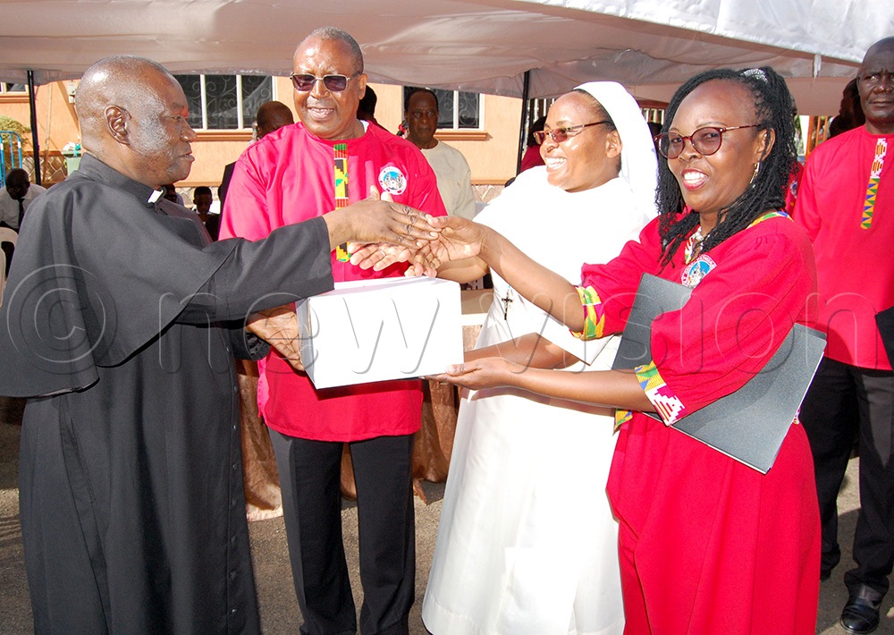 The administrator of Lubaga Cathedral, Fr. Achilles Mayanja (left) gifting the leaders of the visiting choir from Holy Ghost Cathedral Mombasa. (Photo by Mathias Mazinga)