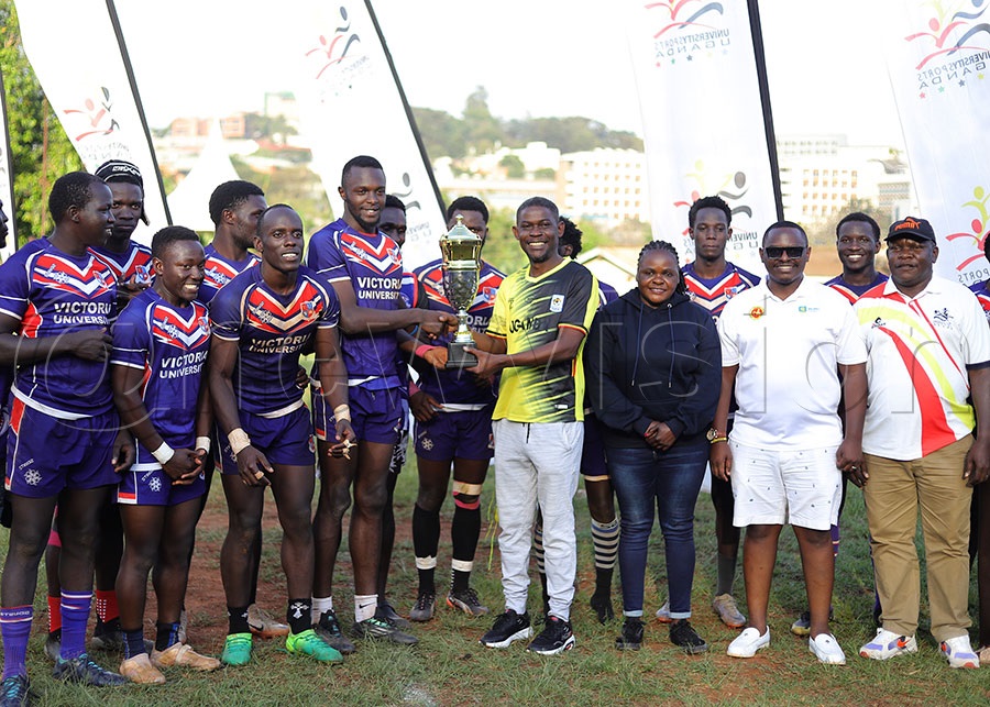 AUUS president George Wagogo (C) hands over the trophy to Victoria University team captain Calvin Gizamba at Makerere University. Looking on (R) is AUUS secretary Patrick Ssebuliba, URU Rugby 7s chairman Desire Mugumisa and age grade rugby manager Dorothy Nekesa. PHOTO: Johnson Were