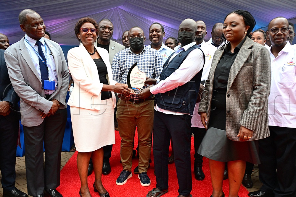 Health minister Ruth Aceng hands over a congratulatory pleque of strength and hope to the first bone marrow transplant patient Sande Stephen upon his discharge from Uganda Cancer Institute. He is accompanied by his caretakers Andrew Ayazika, UCI Board Chairperson Prof. Damalie Nakanjako, UCI ED Dr Jackson Orem other medical officers This was at the UCI in Mulago on April 24, 2026. (Photo by Maria Wamala)