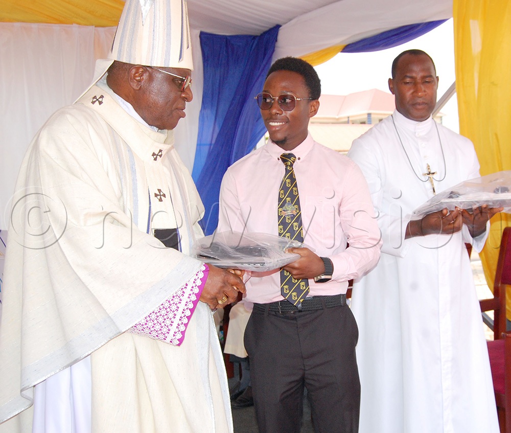 Archbishop Paul Ssemogerere rewarding one of SMACK's UACE star performers. On the right is the headteacher, Bro. Simeon Simon Mpanga. (Photo by Mathias Mazinga)
