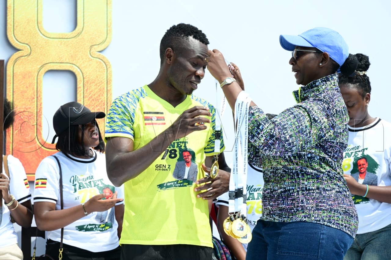 Emmanuel Okwi, who featured for the Parliamentary Staff Team, receives a medal from Brig. Charity Bainababo following the friendly match at MTN Omondi Stadium, Lugogo. (Credit: Eddie Ssejjoba)