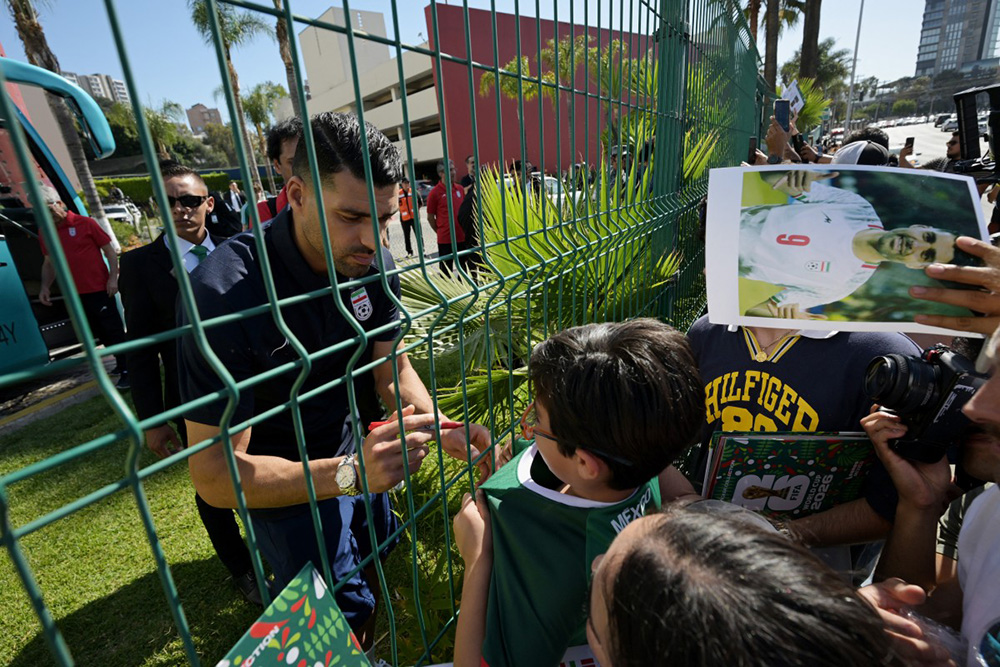 Iran's forward Mehdi Taremi signs autographs for a fan outside the Marriott Hotel before leaving for a training session in Tijuana, Mexico, on June 10, 2026, ahead of the 2026 FIFA World Cup football tournament. (Photo by Guillermo Arias / AFP)