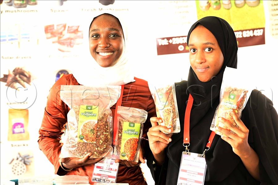 Young women exhibiting pre-cooked beans at Kololo. (Credit: Eddie Ssejjoba)