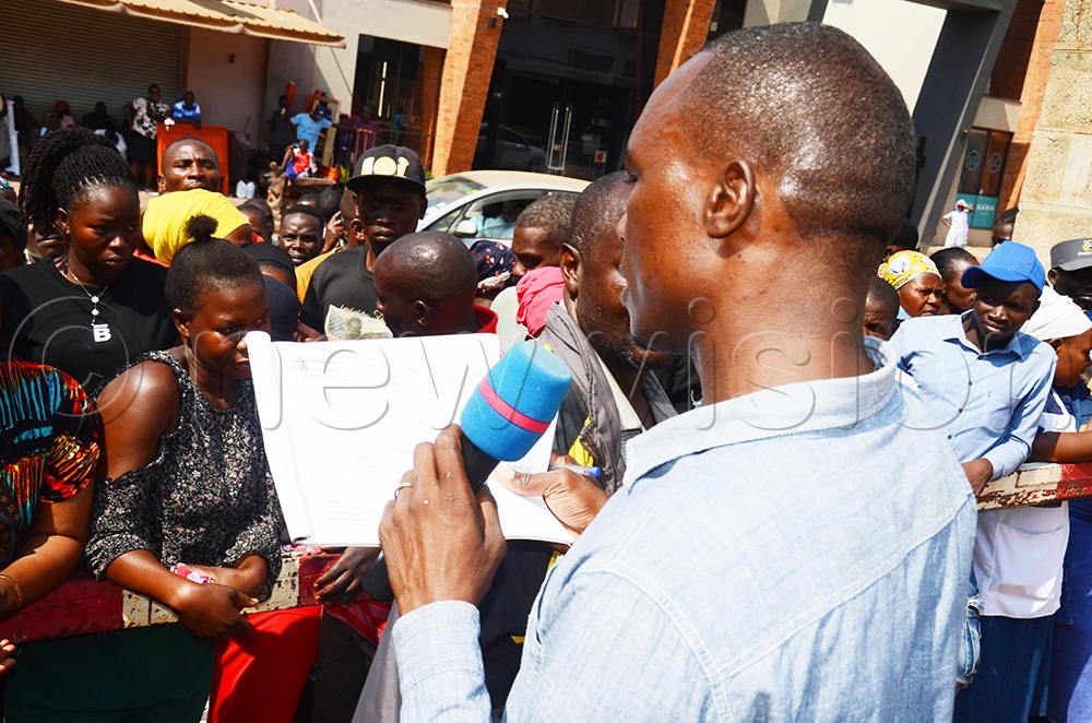 Electoral Commission Observer Bernard Owomuganda reading out names in the register for Pepsi Cola village electoral area on Tuesday, July 28, 2026, shortly before the voting took place. (Photo by Isaac Nuwagaba)