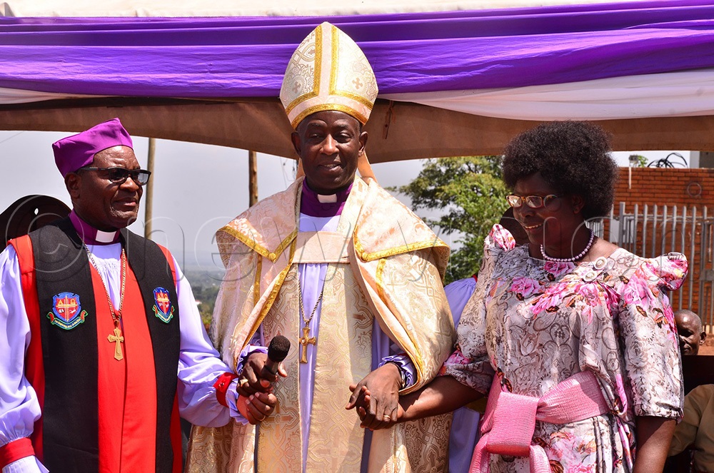 Archbishop Dr Stephen Kaziimba (C) having a chat with Bishop Paul Hannington Suubi and his wife. He commended the bishop and his wife for the impact they have made in two years in East Busoga Diocese. (Photo by Jackie Nambogga)