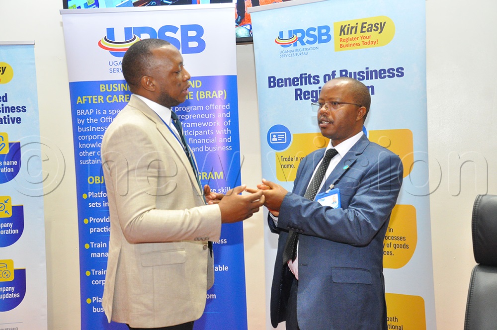 Denis Nabende Communication officer Uganda Registration Service Bureau (URSB) interacting with Robert Mugabe Director Insolvency and Receivership at Uganda Registration Service Bureau (URSB). This was during the business rescue and aftercare program meeting at URBS offices Kololo on February 24, 2025. (Photo by Nancy Nanyonga)