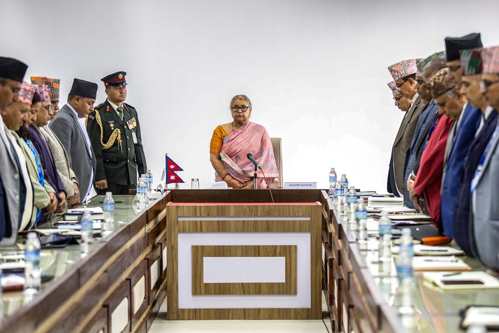 Newly-elected Prime Minister of Nepal's interim government Sushila Karki (C), along with officials, observes a moment of silence to pay her tribute to those who lost their lives in recent protests in Kathmandu on September 14, 2025. (Photo by PRABIN RANABHAT / AFP)