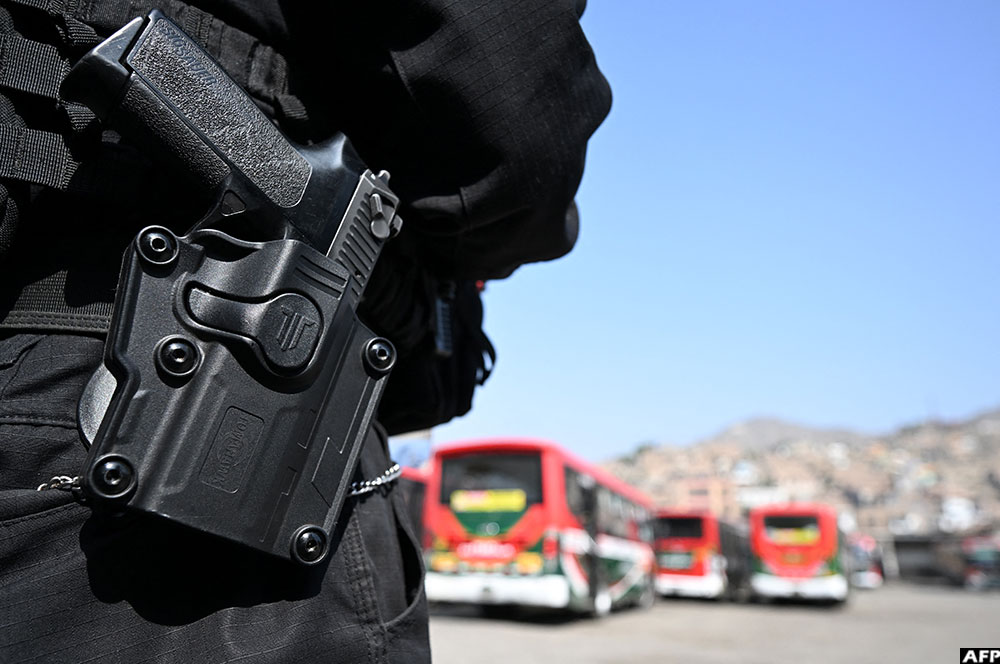 : A police officer stands guard at Santa Catalina bus station, which has been targeted by up to five criminal gangs, at the San Juan de Lurigancho district, east of Lima.