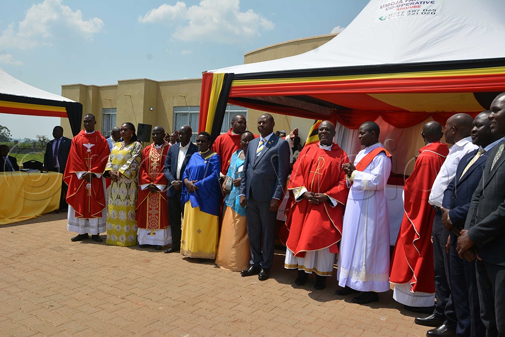 The newly sworn-in Kikuube district chairman, Paddy Kisembo, poses for a photo with the clergy and the state minister for Bunyoro affairs, Mary Mugasa. (Photo by Peter Abaanabasazi)