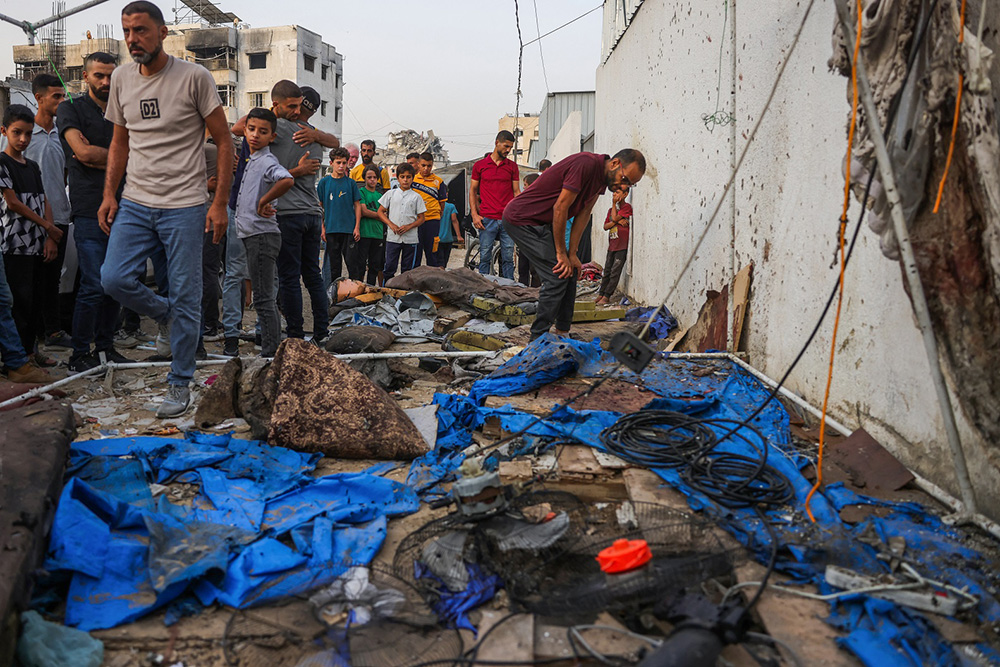 Palestinians check the destroyed Al Jazeera tent at Al-Shifa Hospital in Gaza City on August 11, 2025, following an overnight strike by the Israeli military. Qatari broadcaster Al Jazeera said on August 11, that five of its journalists were killed in an Israeli strike, including a prominent reporter. (Credit: AFP)