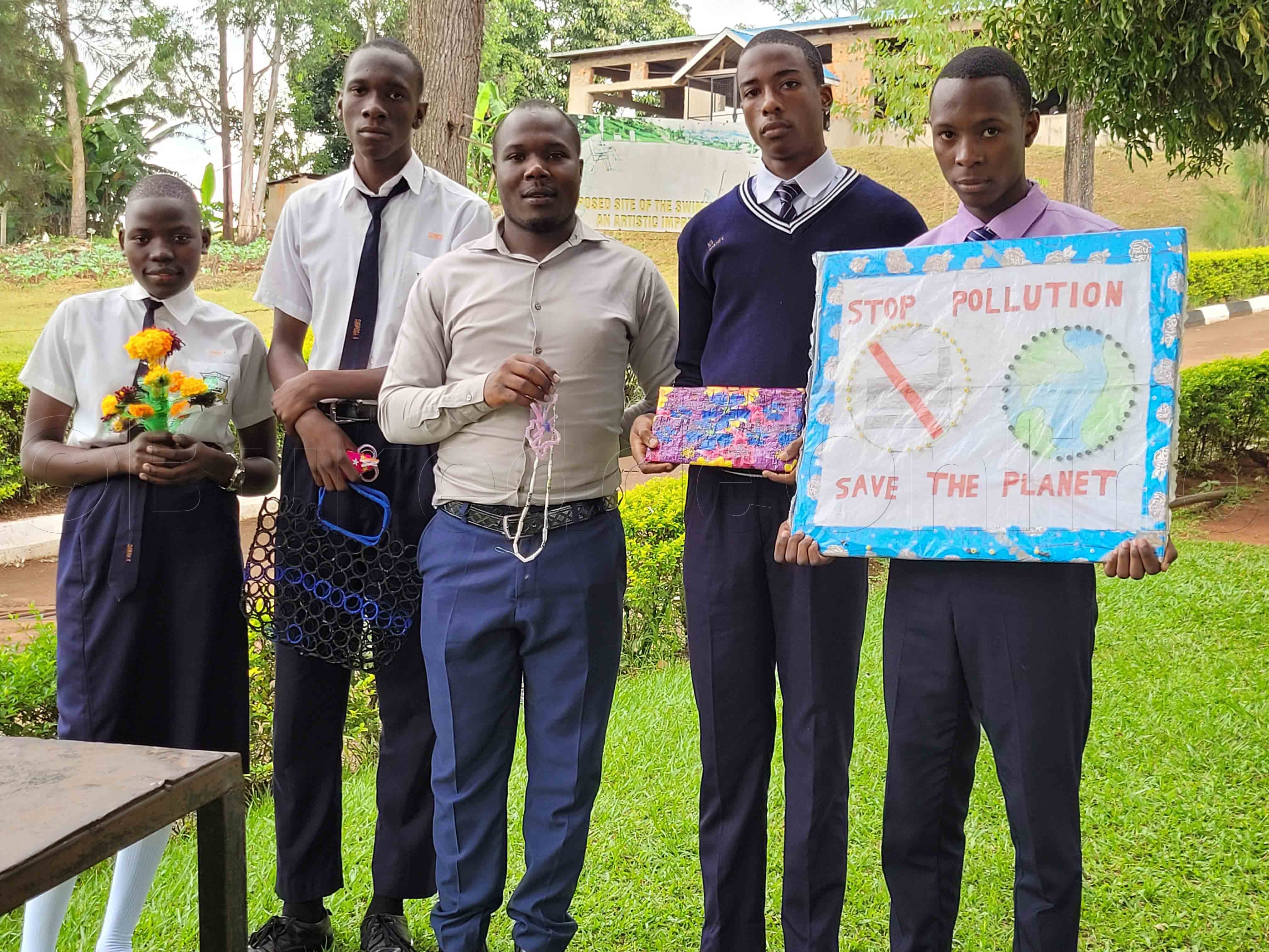 Abayizi n'omusomesa waabwe nga balaga bye bakola mu pulasitiika okumanyisa abantu ku kukuuma obutonde.