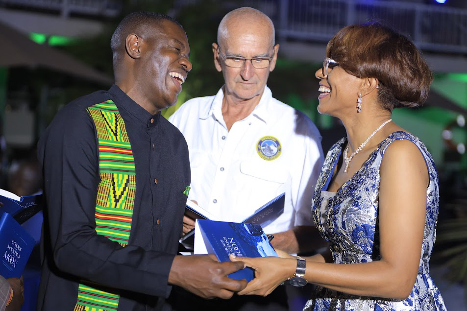Ajarova (right) autographing her book for Simplicious Gessa (left) the UTB public relations manager as John Hunwick the proprietor of Rwenzori Trekking Services looks on.  (Courtesy photo)