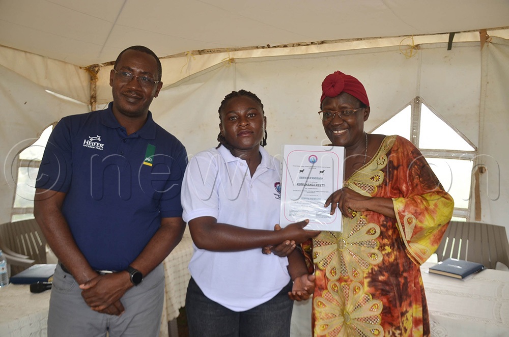 Dr Hellen Nakimbugwe (right) and Silver Turyahikayo (left) handing over a certificate to Resty Komuhangi, one of the AI technicians who graduated. (Photo by Abdulkarim Ssengendo)