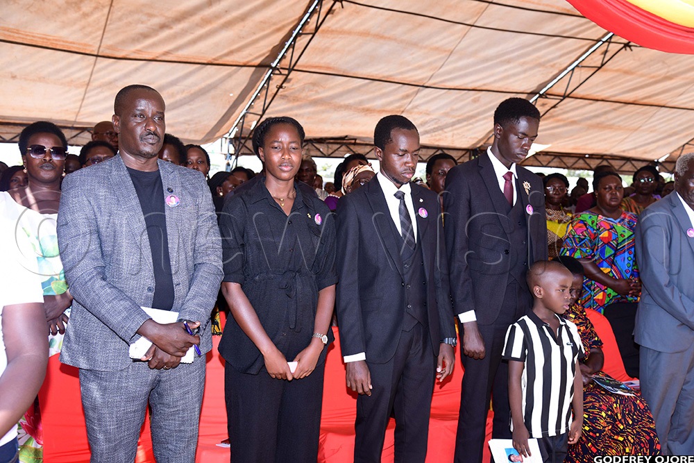 Samuel Isodo and their three children during burial of his late wife and mother to his children, woman MP Stella Apolot Isodo. (Photo by Godfrey Ojore)