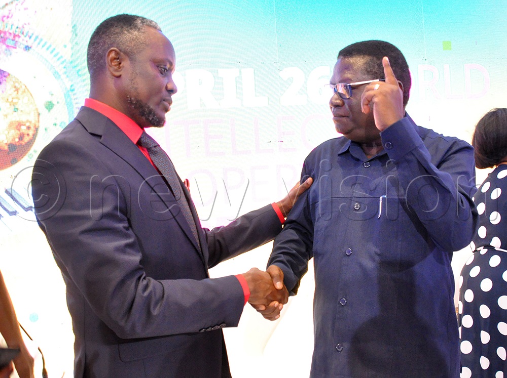 Norbert Mao Minister of Justice and Constitutional Affairs interacting with Hillary Kiyaga aka Hilderman Member of Parliament Mawokota North. (Photo by Nancy Nanyonga)