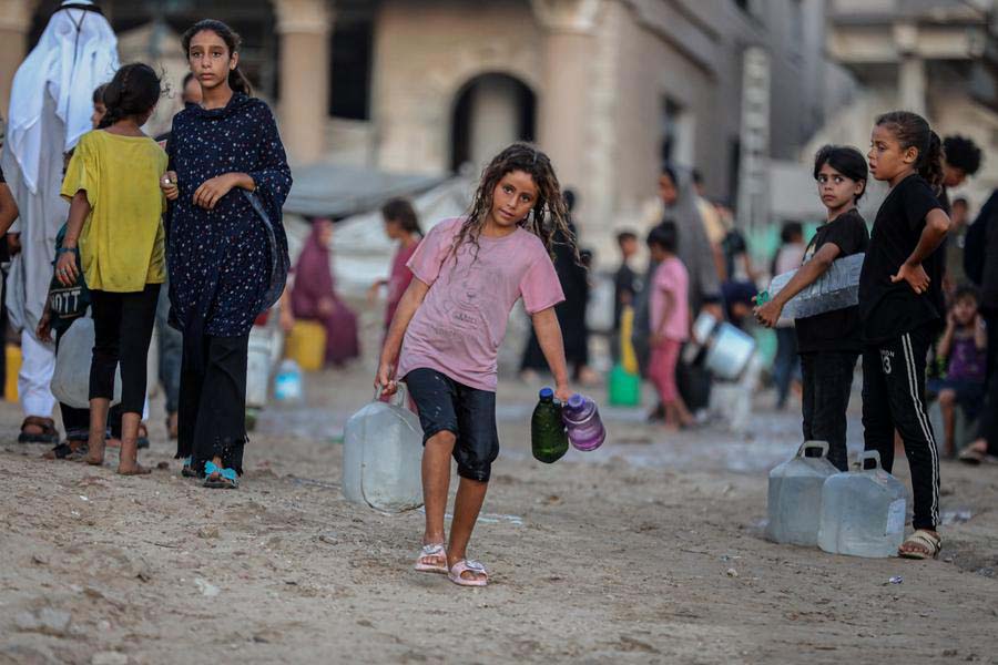 A Palestinian child fetches water near the beach west of Gaza City, on August 18, 2025. (Photo by Xinhua)