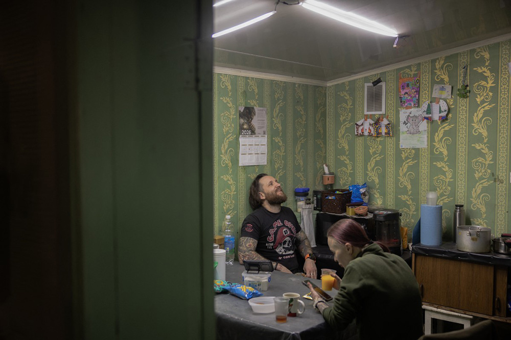 Ukrainian combat medic Anastasia Podobailo (R), with her colleague and husband Mykola Yasinenko rest and eat after treating an injured soldier of the Ukrainian army, at a stabilisation point of the 56th brigade, in the eastern Donetsk region, late on March 15, 2026, amid the Russian invasion of Ukraine. (Photo by Roman PILIPEY / AFP)
