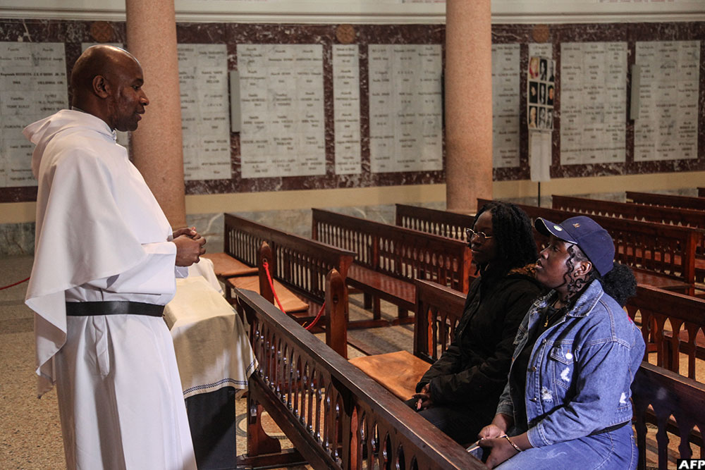 Christian worshippers speak with a member of the clergy inside the Basilica of Saint Augustine. (AFP)