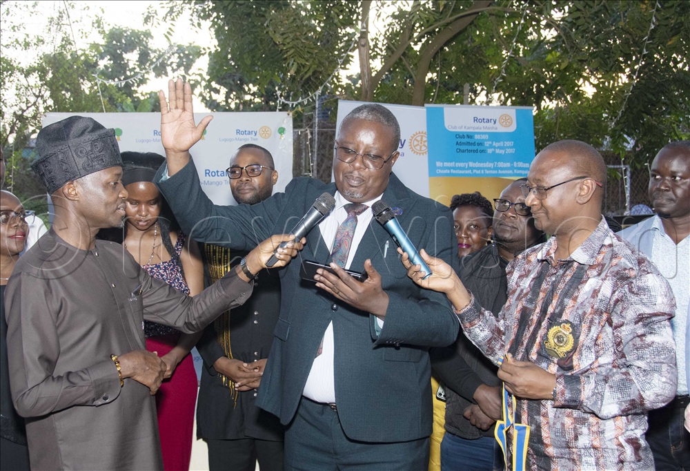 Edmund Owor (middle), takes the oath of office as the new President of the Rotary Club of Kampala Maisha, at a joint installation function with the Rotary Club of Lugogo-Mango Tree, held at the Shell Club, Lugogo on Saturday. He was installed by the District 9213 Governor, Geoffrey Kitakule, right, and Past District Governor Kenneth Mugisha, left.