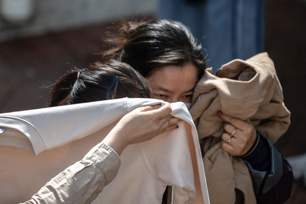 People leave after identifying bodies in the aftermath of a major fire that swept through several apartment blocks at the Wang Fuk Court residential estate in Hong Kong's Tai Po district on November 28, 2025. 