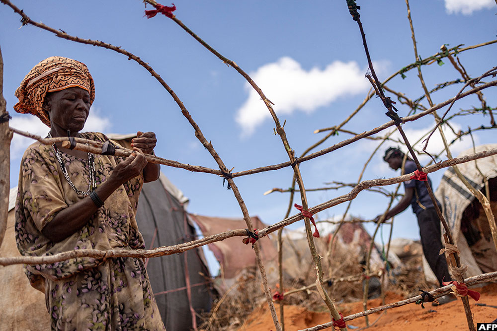 A newly arrived Somali woman builds her family hut in an internally displaced persons (IDP) camp in the outskirts of Kismayo town. (AFP)