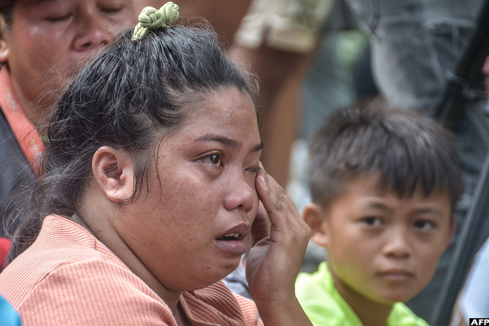 A woman waits as rescuers continue search operations after the landslide at a landfill in Barangay Binaliw. (AFP)