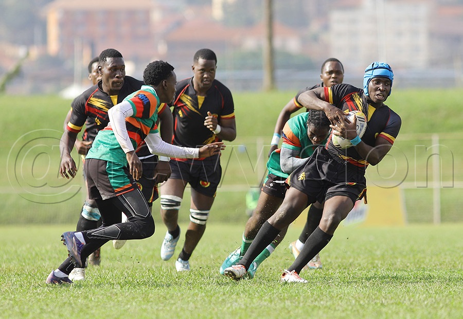 Uganda's Abraham Mujuni is tackled by Zambian opponents during the U20 Barthes Cup