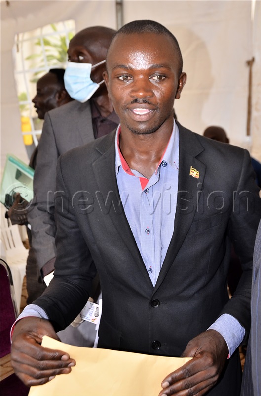 An aspiring presidential candidate, Baguma Allan Mugisha carrying an envelope contains nomination forms during pick of forms for presidential candidates at Electoral Commission offices in Kampala on 11 Aug 2025.