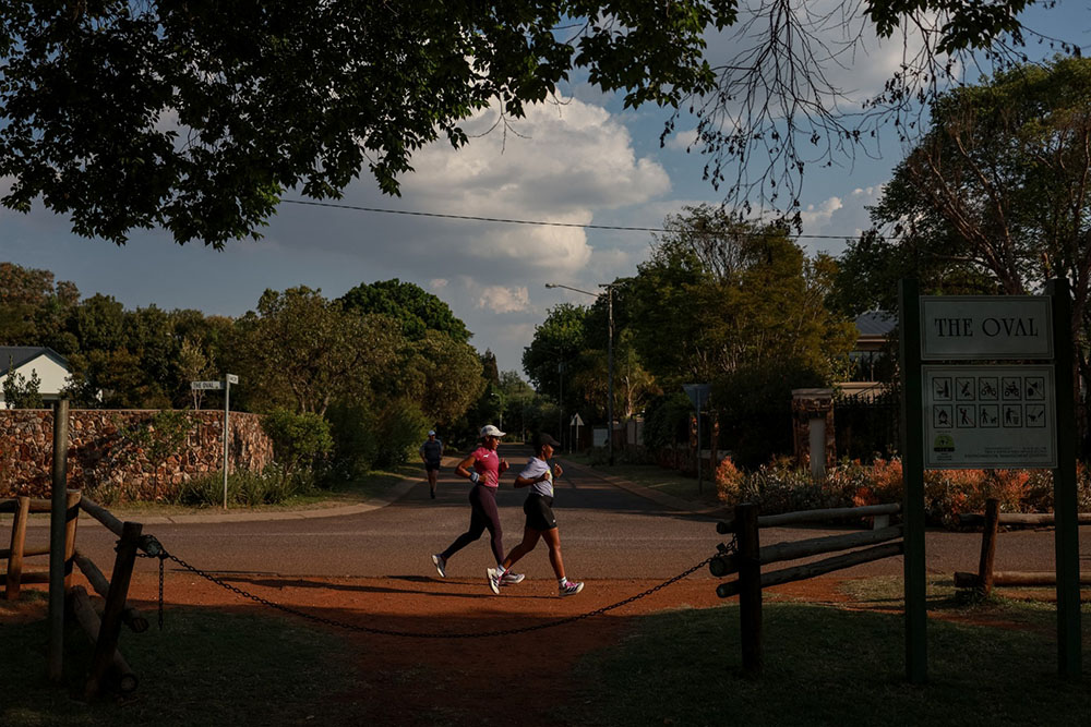 Nancy Masha (R) and Babalwa Melitafa (L) run inside a gated community next to a cricket oval in Irene, south of Pretoria on September 21, 2026. Gender-based violence remains endemic in South Africa, despite years of government pledges to tackle the problem and declaration it as a national disaster. AFP