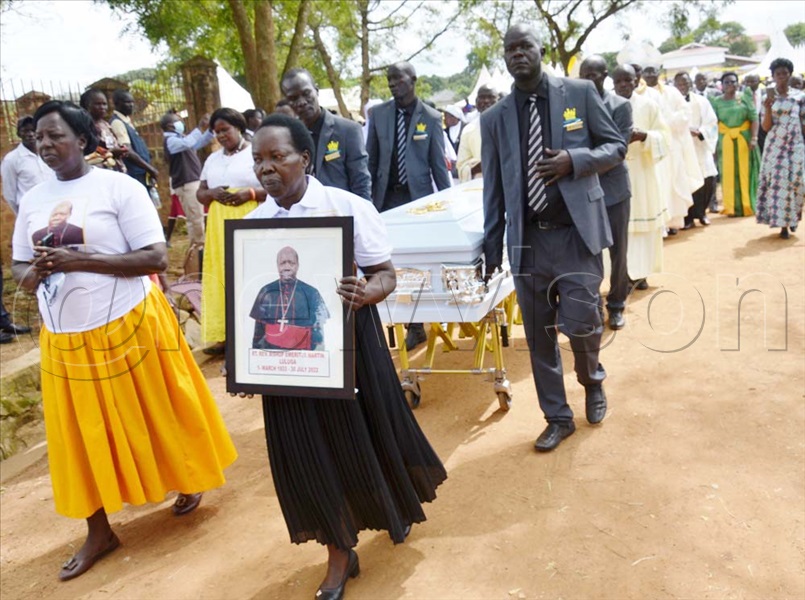Late Bishop Martin Luluga's sister carrying the portrait during the sendoff. (Photo by Robert Adiga)