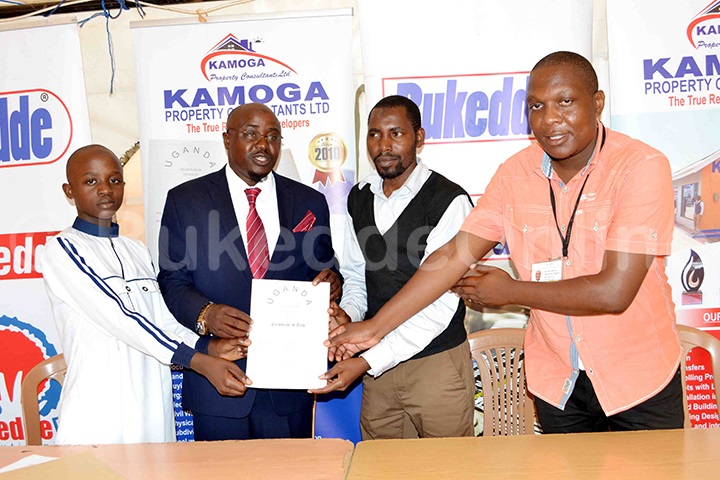 Hajji Muhamadi Kamoga ne mutabani we nga bakwasa Farid Mpagi ne Simon Maseruka aba Bukedde ekyapa ky'ettaka kye bawaddeyo mu byassava bya Iddi