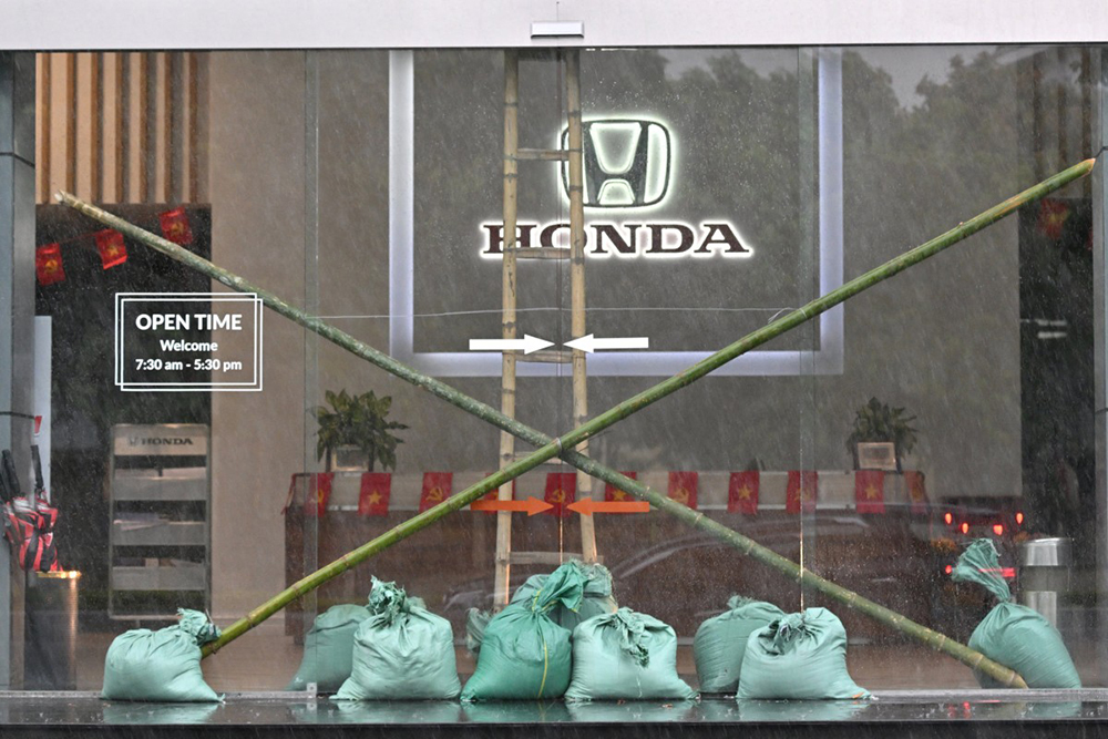 The entrance of a car dealership is seen reinforced by sandbags and bamboo stakes in Vinh city, Nghe An province on August 25, 2025, before Typhoon Kajiki makes landfall in Vietnam. 