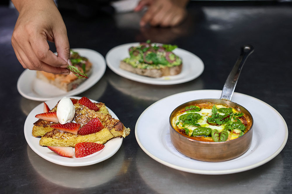 A chef prepares half-sized portions of their brunch tasting at Le Petit Village restaurant on December 10, 2025 in New York City.