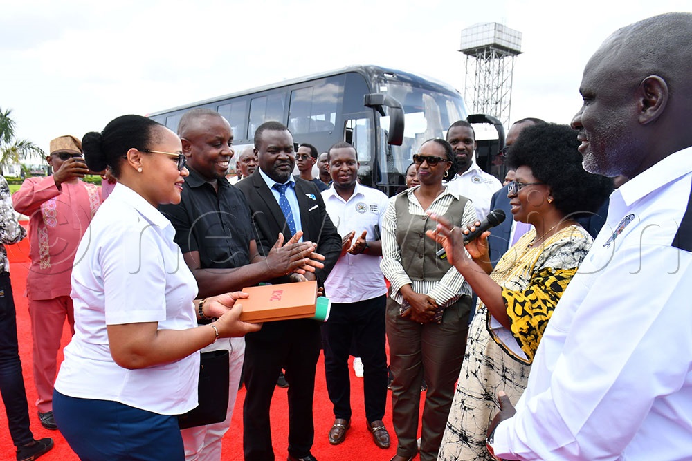  The Minister of Science, Technology and Innovation Monica Musenero (2nd right) remarking after handing over documents and keys of one of the Premium electric coaches registration number UA 287BJ to staff of UCAA who included UCAA's Procurement Manager Helen Hannah Tumuhimbise (left), UCAA's Principal Transport and Maintainance Officer Nicholas Tayebwa (2nd left) and UCAA's Public Affairs Principal Officer Kenneth Otim (3rd left). (Photo by Donald Kiirya)