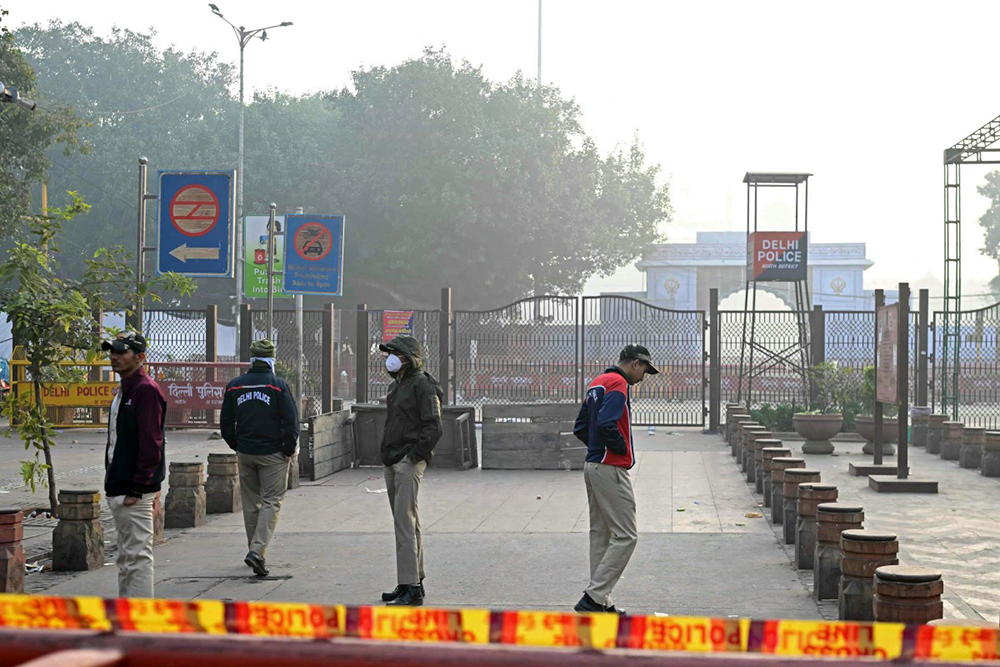 Policemen stand guard near the blast site, after an explosion in the Red Fort area in the old quarters of Delhi, on November 12, 2025. 