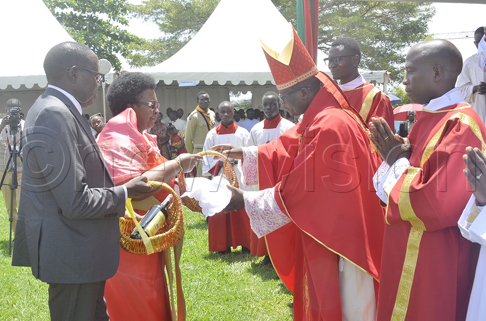 The Bishop of Lira Diocese, Sanctus Lino Wanok, receives offertory from Hon. Margaret Nantongo Zziwa, Head of Laity at Our Lady and St. Jude Thaddeus Shrine, Naggulu, and her deputy during a celebration on Wednesday, October 28, 2026. (Photo by Juliet Anna Lukwago).