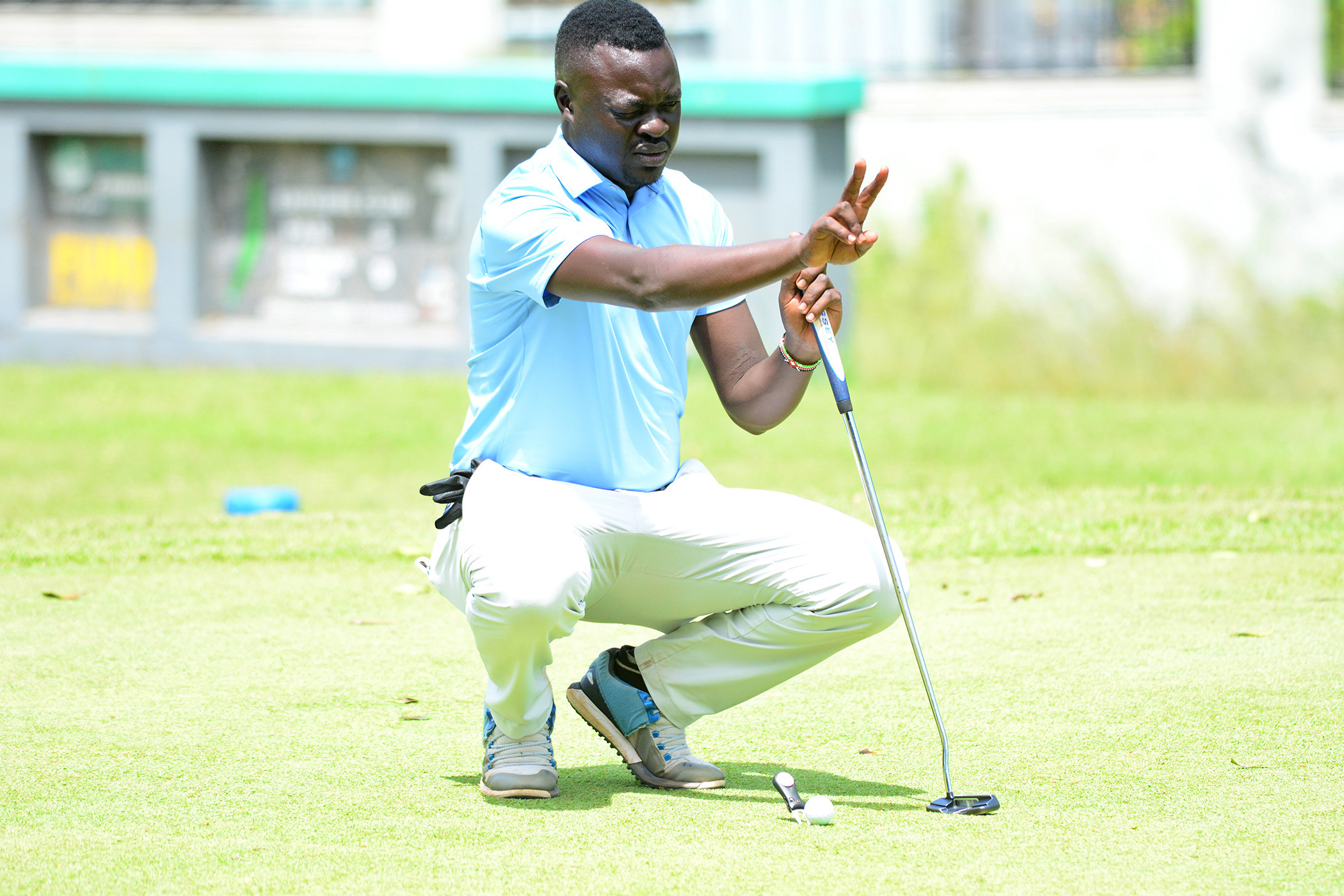 Joseph Cwinyaai reads his line before putting.