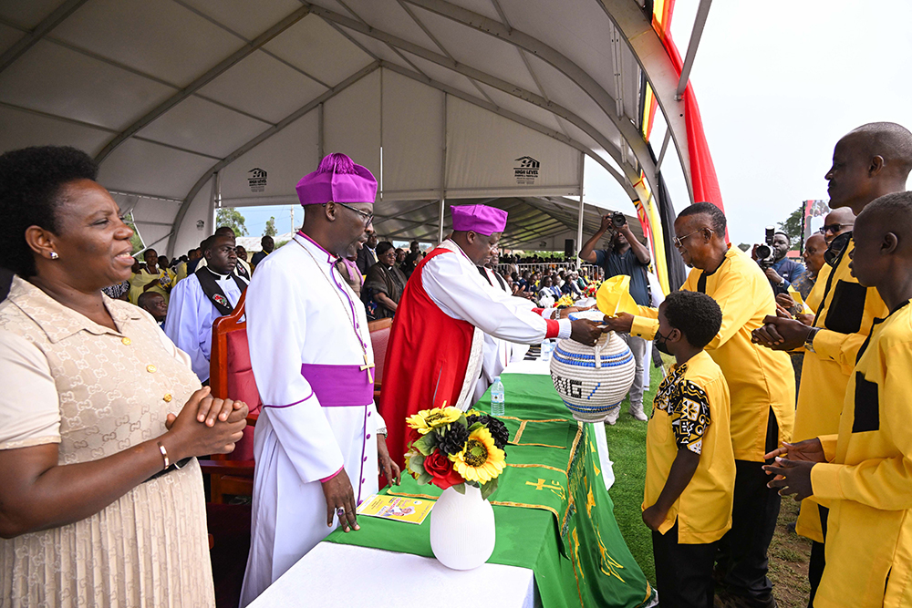 Prof. Ephraim Kamuntu presents the offertory basket to the bishops during his thanksgiving ceremony in Sheema on Saturday. (PPU Photo)