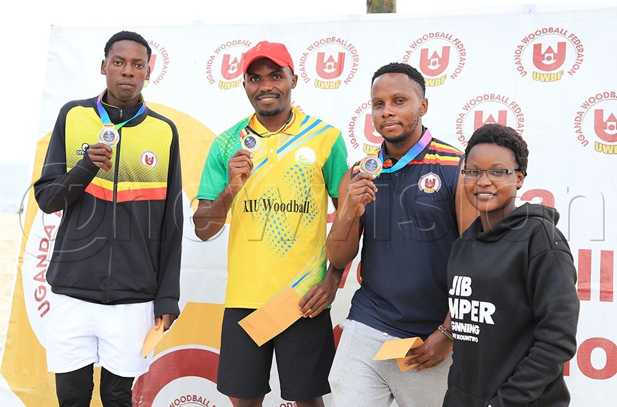 Joan Mukoova (C) gold winner , Jackie Naula (L)  Silver winner and Denise Nanjeru bronze winner pose for a photo with Uganda Woodball Federation official Ramathan Nagoso