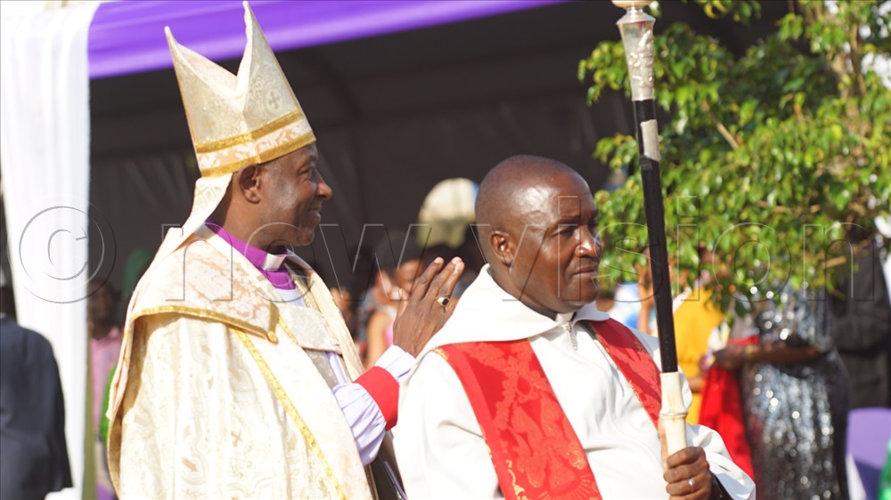 Archbishop Stephen Kaziimba (Left), the head of the Church of Uganda waving to the congregants.