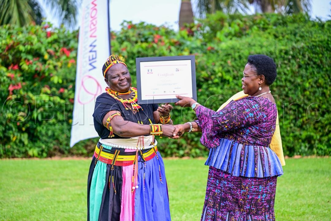 Minisita omubeezi ow'ebyenjigiriza bya Pulayimale, Dr. Joyce Morik Kaducu ng'agabira omusomesa satifikeeti.