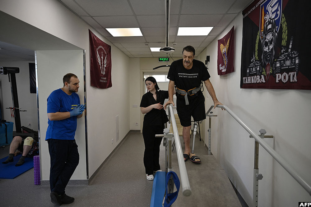A resident of Dnipro, Yurii Lavrik (R), 66, does exercises in the Recovery rehabilitation centre of the Mechnikov Hospital in the city of Dnipro on June 8, 2026