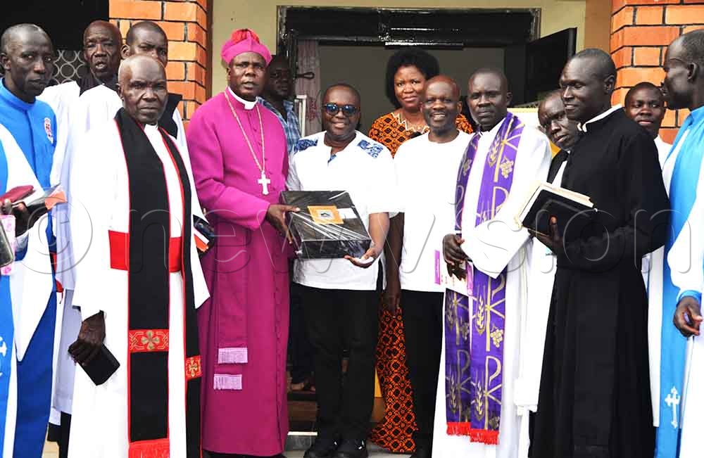 Ocici and other family members hand over a gift to Bp Odongo after the prayers. (Credit: Delux Emmy Alomu)