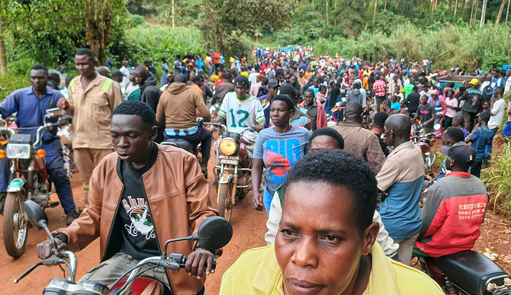Residents gather at the scene of the accident. (Photo by Peter Abaanabasazi)