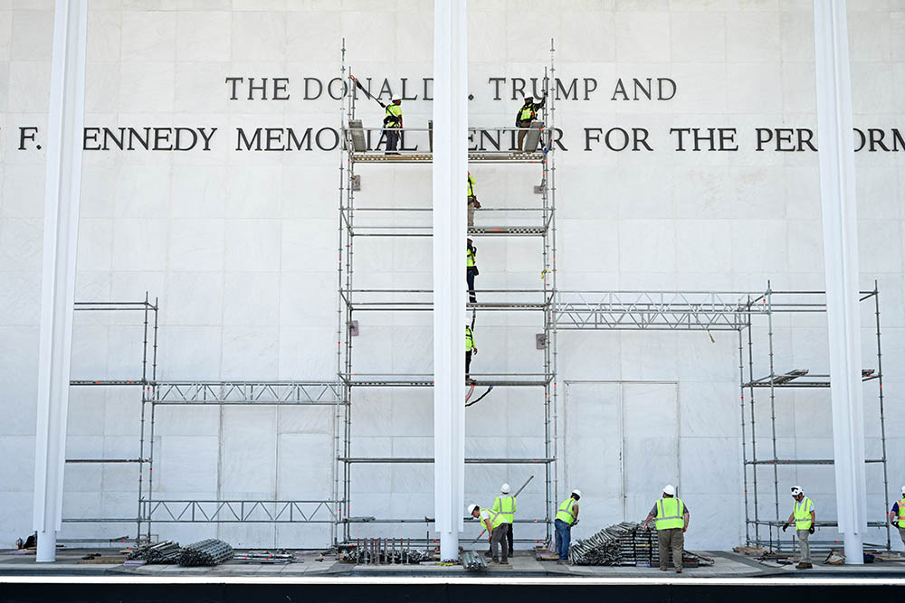 Workers build scaffolding near the signage for the "Donald J. Trump and John F. Kennedy Memorial Center for the Performing Arts" in Washington, DC, early on June 13, 2026.